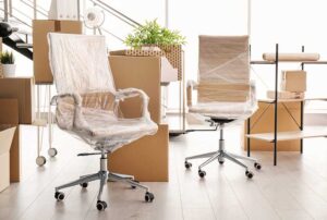 office furniture and boxes being packed and protected for commercial relocation